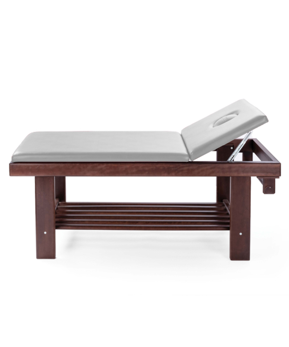 Lettino da massaggio in legno massello colore noce scuro con schienale regolabile, ripiano portaoggetti e cuscino antimicrobico.